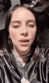 a close up of a woman taking a selfie with her eyes closed and her mouth open .