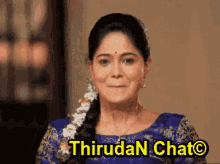 a woman in a blue top with flowers in her hair is smiling with the words thirudan chat above her