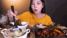 a woman is holding a fork over a bowl of food .
