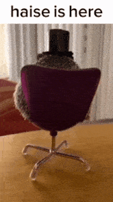 a hedgehog wearing a top hat is sitting in a chair with the text haise is here