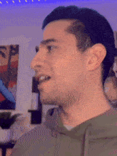 a close up of a man 's face with a painting behind him
