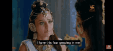 a woman in a blue dress is talking to another woman in a video .