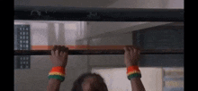 a person is hanging upside down on a bar with their hands on it .