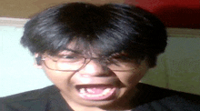 a young man wearing glasses is making a funny face with his mouth open