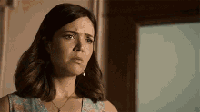 a woman in a blue dress is making a funny face .