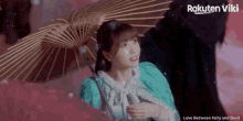 a woman in a blue dress is holding an umbrella with the words love between fairy and devil on the bottom