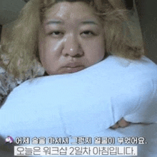 a woman is laying on a bed holding a pillow in her mouth .