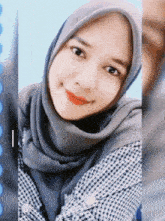 a woman wearing a hijab and a plaid shirt is smiling