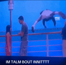 a man and a woman standing on a balcony with the words im talm bout innittt written below them
