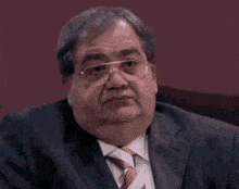 a man in a suit and tie is smiling with his mouth open