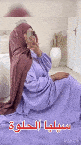 a woman in a purple dress is taking a picture of herself with her phone