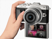 a hand is holding a camera that says olympus pen on it