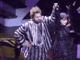a man in a striped suit is dancing with a woman