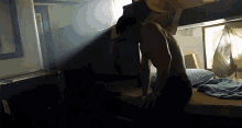 a man without a shirt is sitting on a bed in a dark room