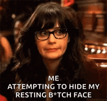 a woman wearing glasses is making a funny face while sitting at a table .