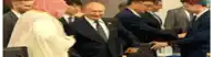 a man in a suit and tie is shaking hands with another man in a suit and tie .