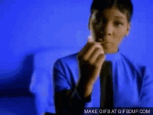 a boy in a blue shirt is eating a candy bar