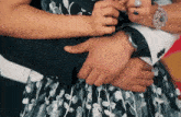 a woman is holding a man 's arm while wearing a watch