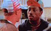 a man wearing a colnago hat looks at another man