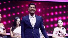 a man in a blue suit is standing in front of a take me out sign