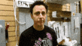 a man wearing a black t-shirt with a pink logo on it