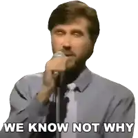 a man singing into a microphone with the words we know not why behind him