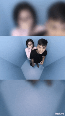 a man and a woman are standing in a blue room with intolive written on the bottom right
