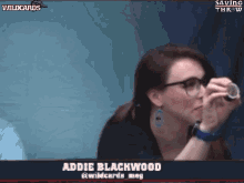 a woman wearing glasses looks through a magnifying glass with the name addie blackwood at the bottom
