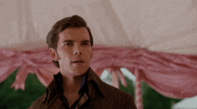 a man stands in front of a pink tent