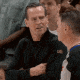 a man wearing a black jacket with the word cavs on the sleeve