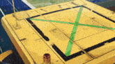 a yellow box with a green x on the bottom