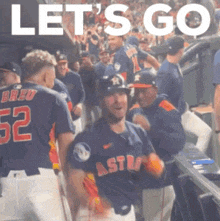 a group of baseball players are standing in a dugout with the words let 's go in the background