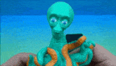a person is holding a green octopus toy with orange tentacles .