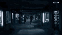 two people are running in a dark hallway with a netflix logo on the bottom