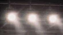 a row of lights hanging from a ceiling with a blurred background