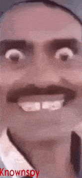a close up of a man 's face with a mustache and teeth .