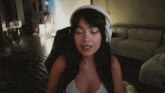 a woman wearing white headphones is sitting in a chair with her eyes closed