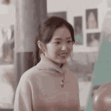 a woman is wearing a turtleneck sweater and smiling .