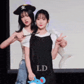 a girl in a pirate hat is cutting another girl 's braid with scissors