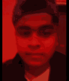 a man wearing a bandana and a hat is looking at the camera with a red background .