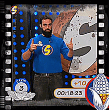 a man in a blue shirt with the letter s on it giving a thumbs up