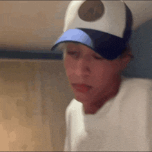 a person wearing a white hat with a blue brim and a circle on it