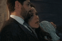 a man in a suit and tie is hugging a woman in a dress .