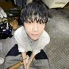 a young boy is kneeling on the floor in a room .