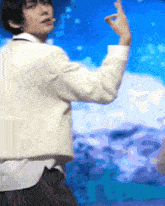 a man in a white jacket is standing in front of a blue and purple background .