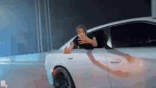 a man in a black hat is sticking his head out of a car window