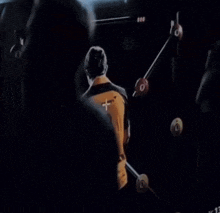 a man wearing a yellow mclaren shirt is looking at a screen