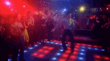 a man is dancing on a dance floor in front of a crowd of people in a club .