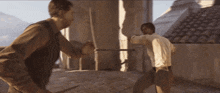 two men are fighting each other on a balcony in front of a window