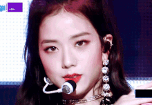 a close up of a woman 's face with a microphone in her mouth .
